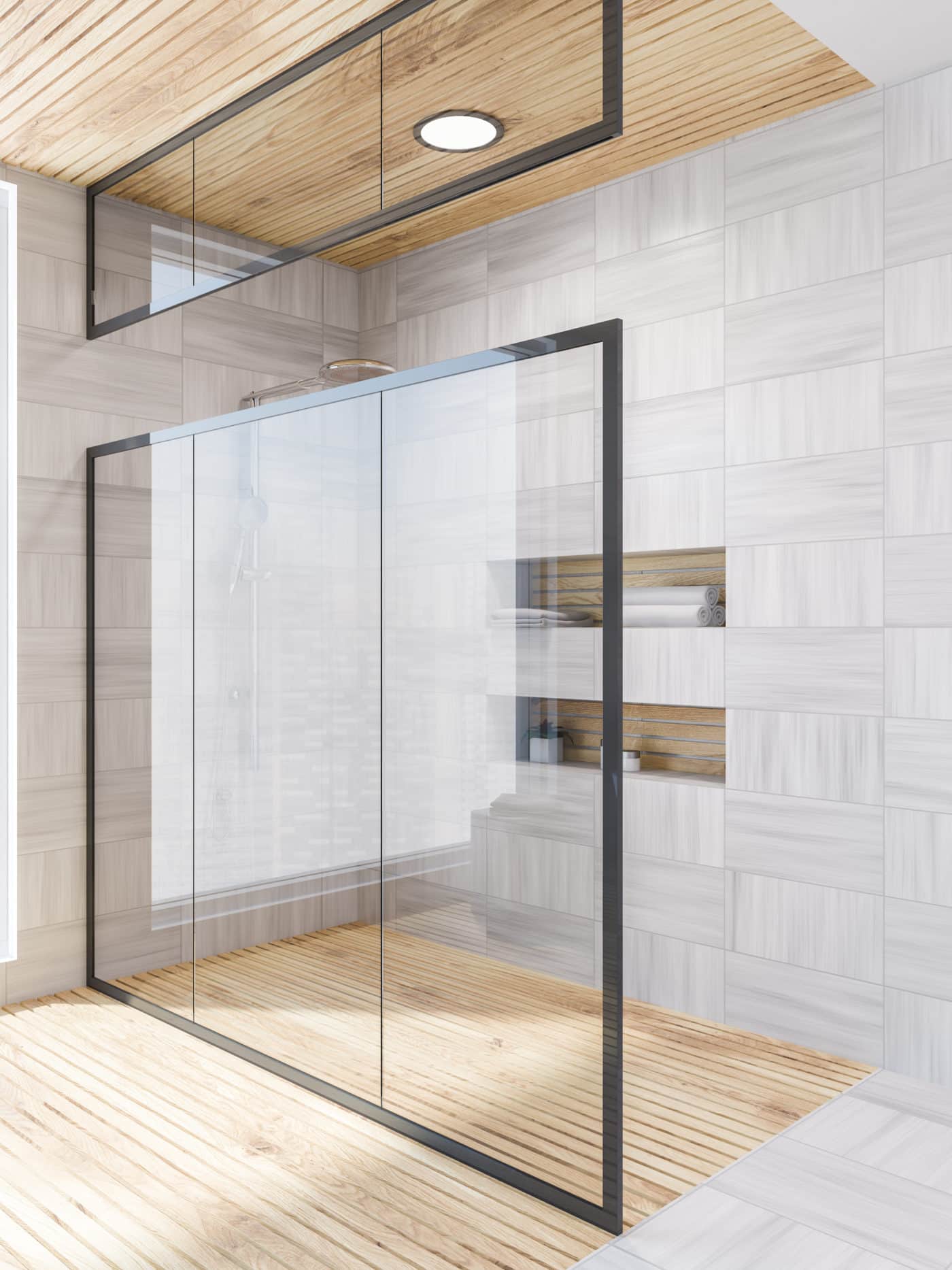 A bathroom with a glass shower door and wooden floors.