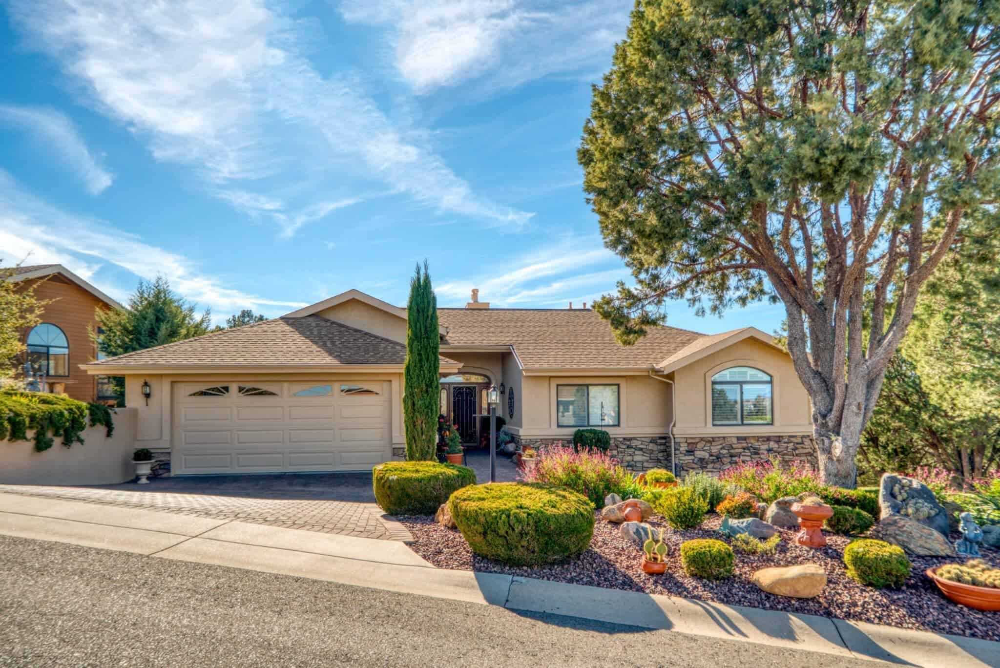 A home with a beautiful front yard featuring trees and a well-maintained driveway, exuding curb appeal.