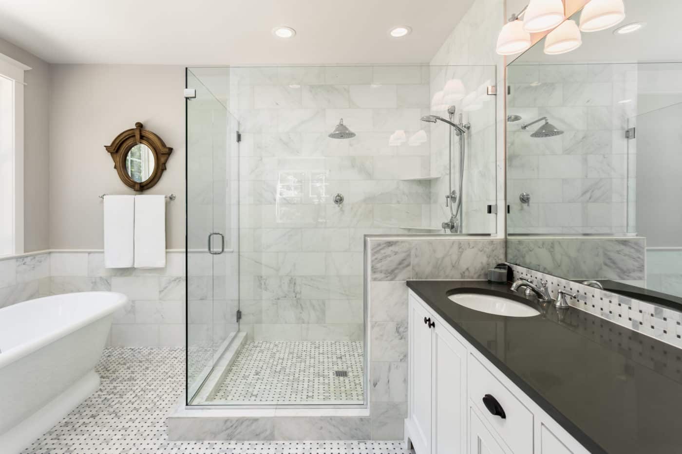 A white and black bathroom with a glass walk-in shower stall.