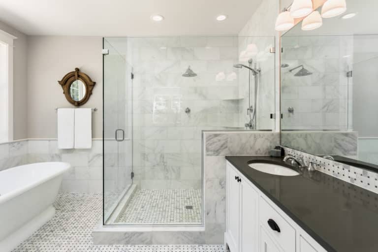 A white and black bathroom with a glass walk-in shower stall.
