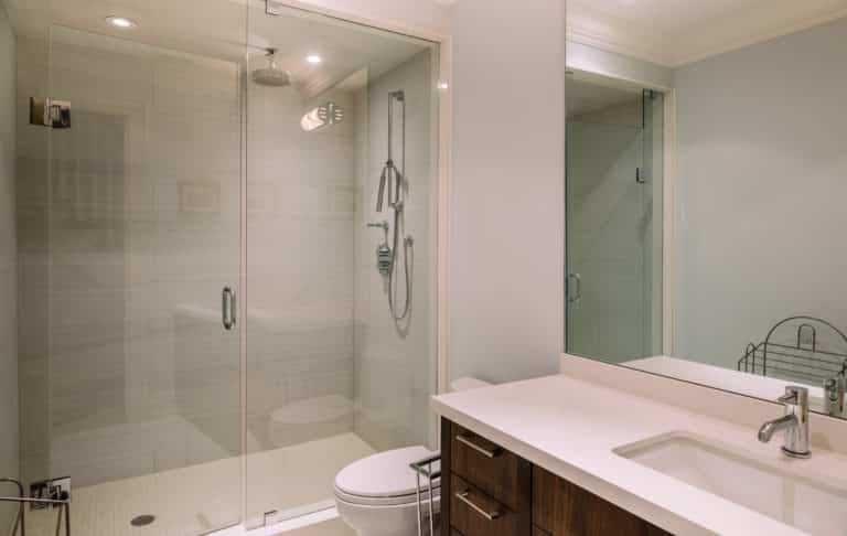 A modern bathroom with a glass shower stall and sink.