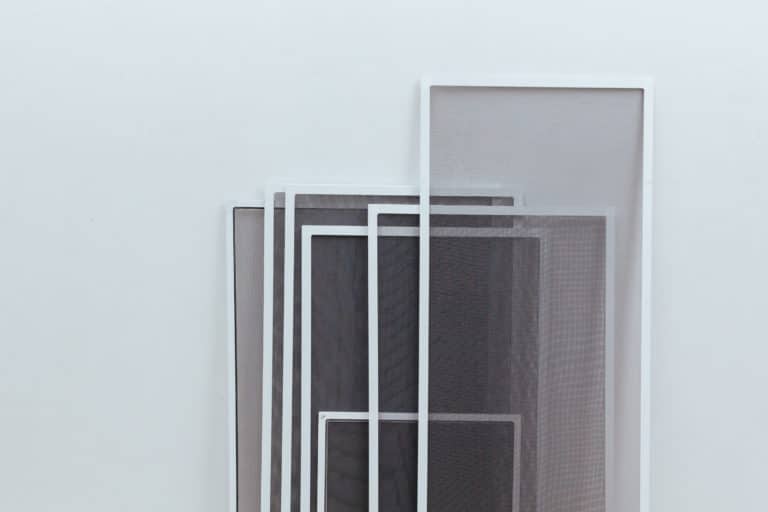 A white wall adorned with a stunning arrangement of black and white frames.