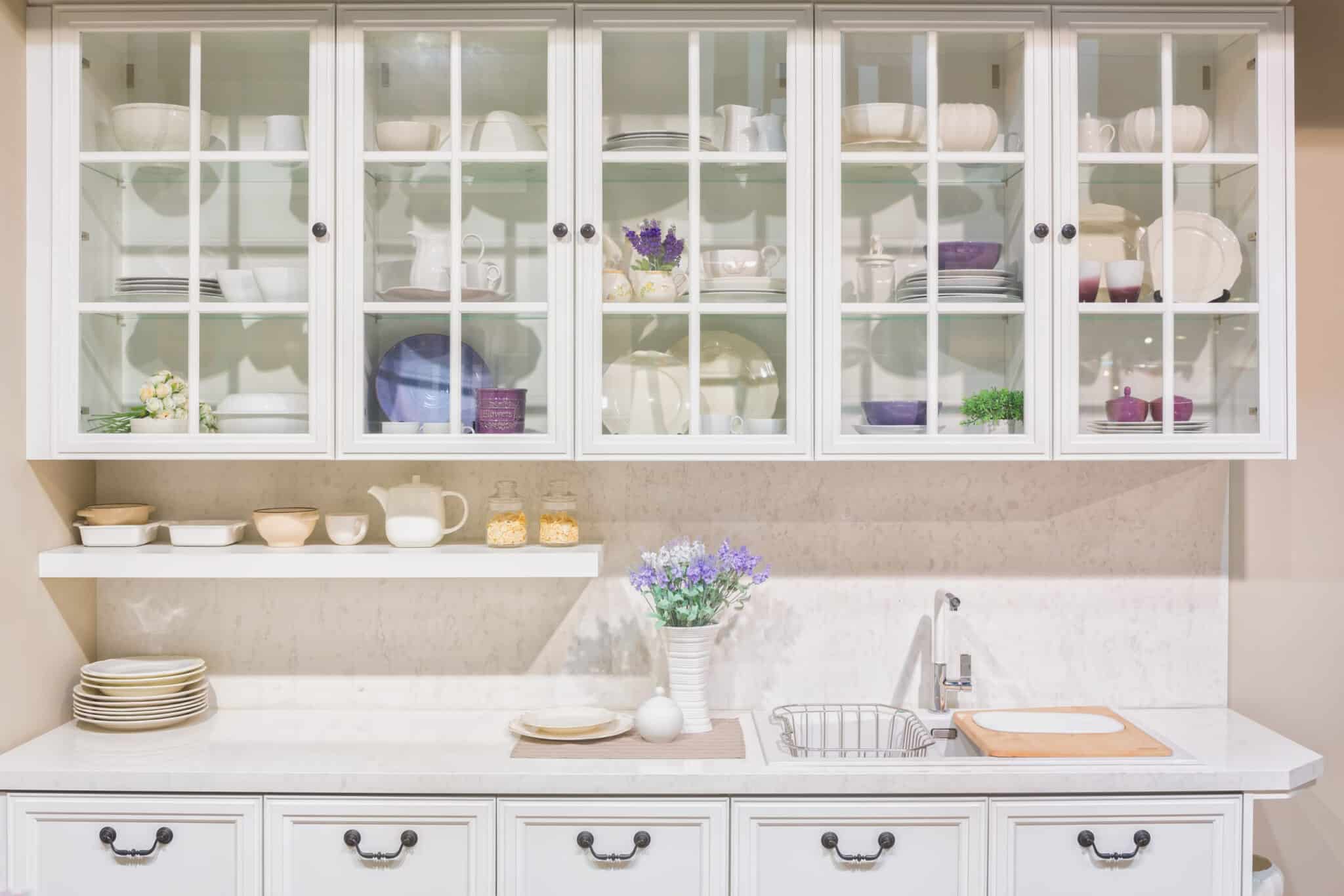 Bright white kitchen with glass cabinet doors.