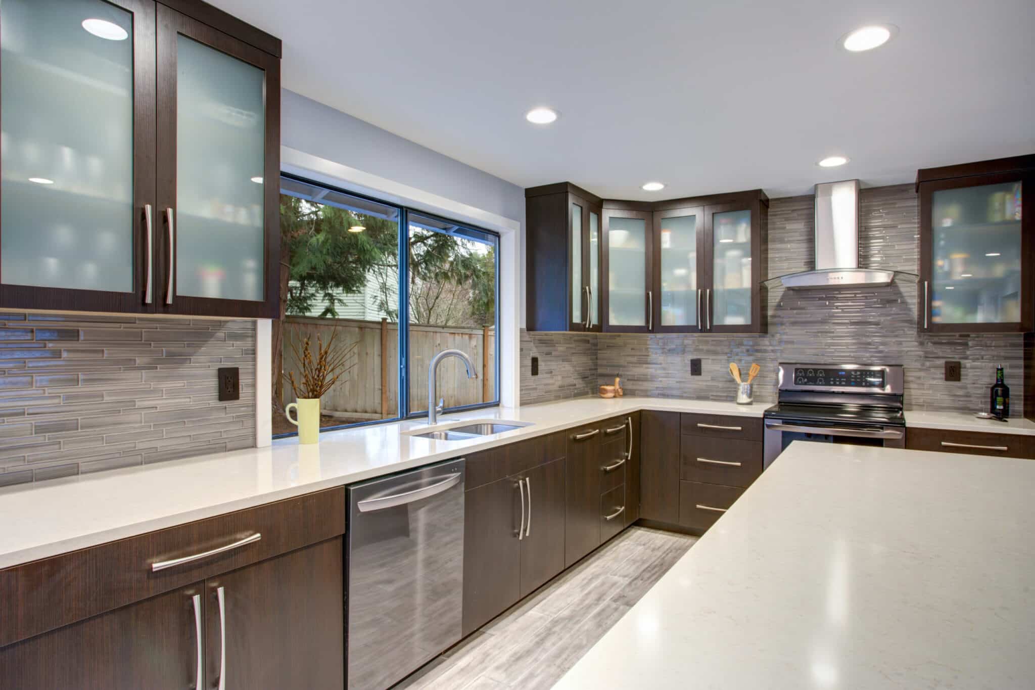 Bright and airy kitchen with dark cabinets and glass doors.